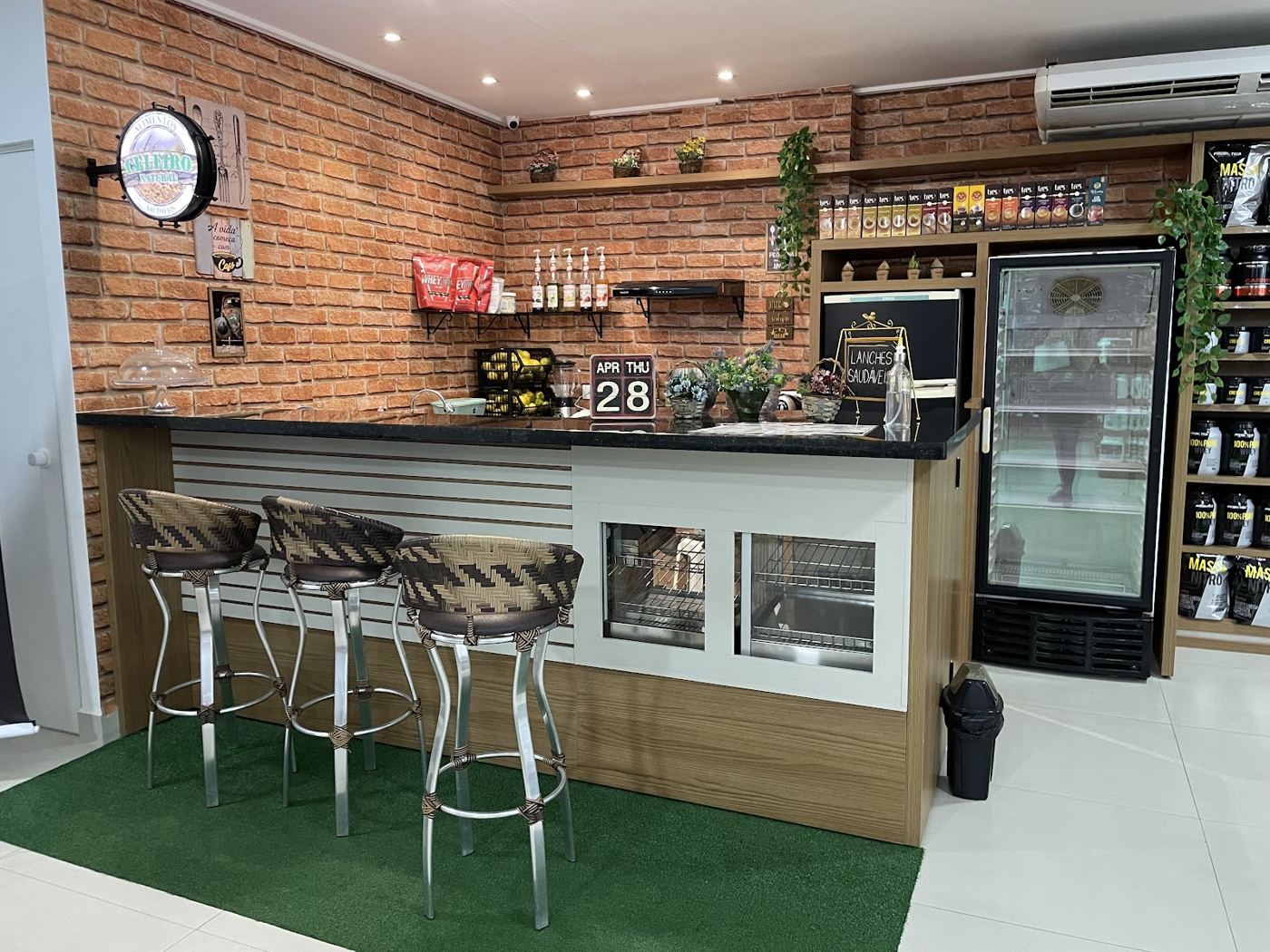 Espaço Gourmet com balcão, banquetas e parede de tijolos